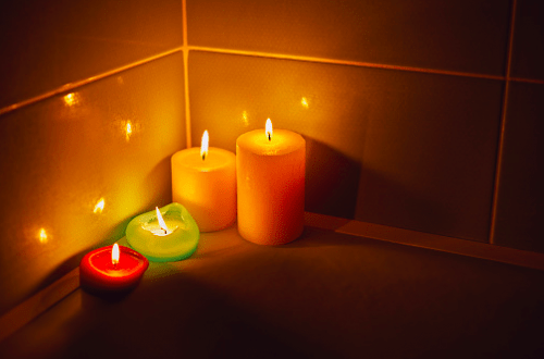 Colorful lit candles in bathtub corner - Improve Sleep Quality