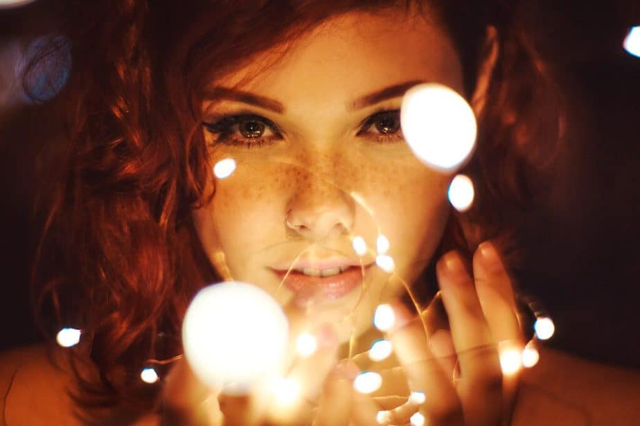 Woman holding strings of illuminated fairy lights - mood setting