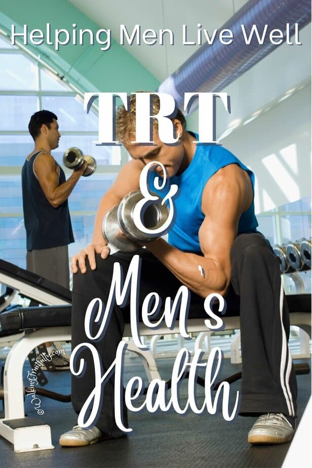 Man wearing blue shirt sitting on weight bench doing bicep curls with other man working out in background