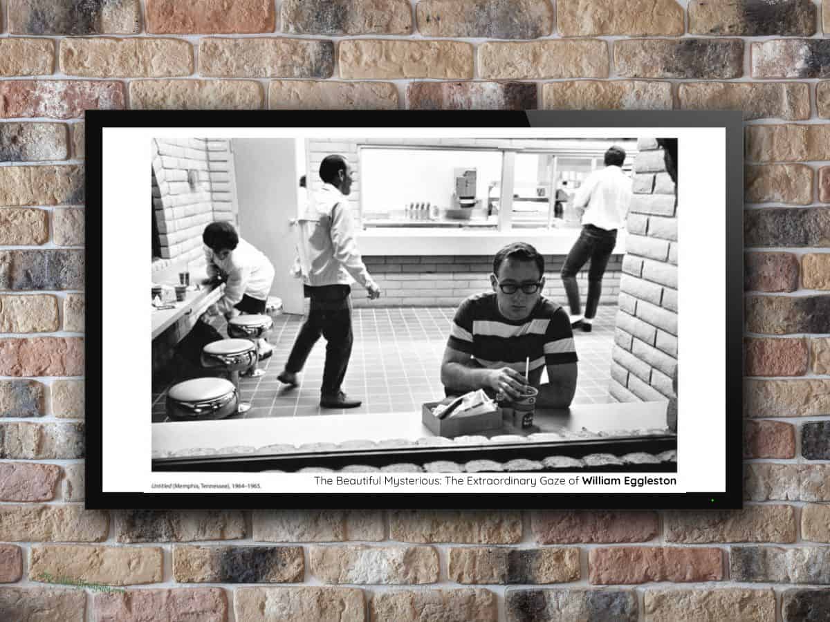 Black and white photograph in black frame hanging on brick wall