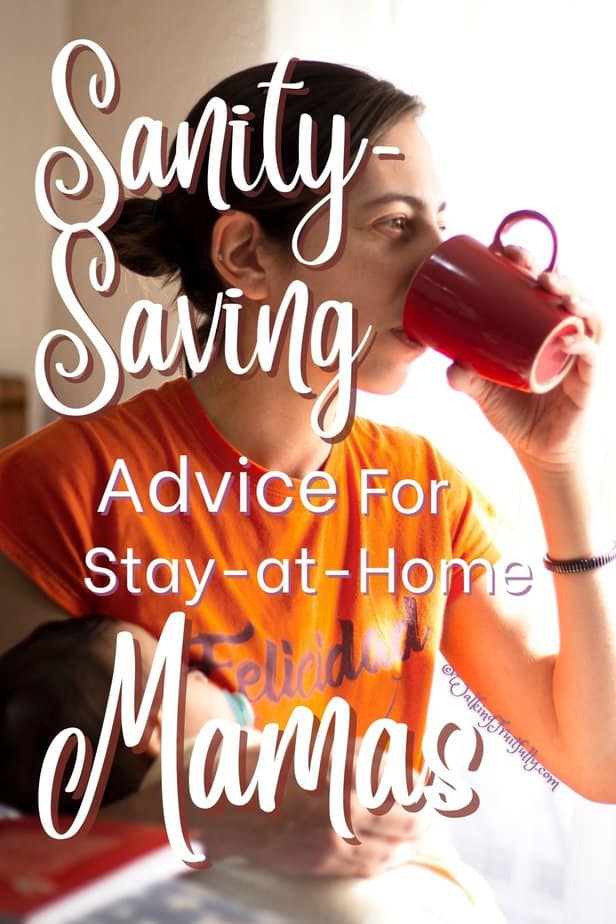 Seated woman in orange shirt drinking from red mug holding sleeping infant with bright window behind | Sanity-Saving Advice for Stay-at-Home Mamas