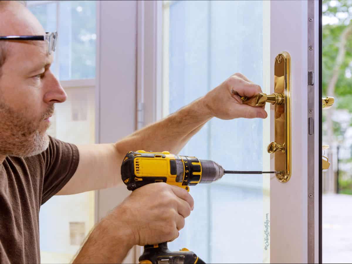 Man installing door hardware on exterior door of home.