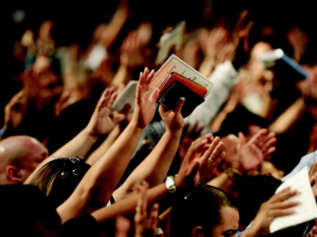 A crowd with hands raised in worship