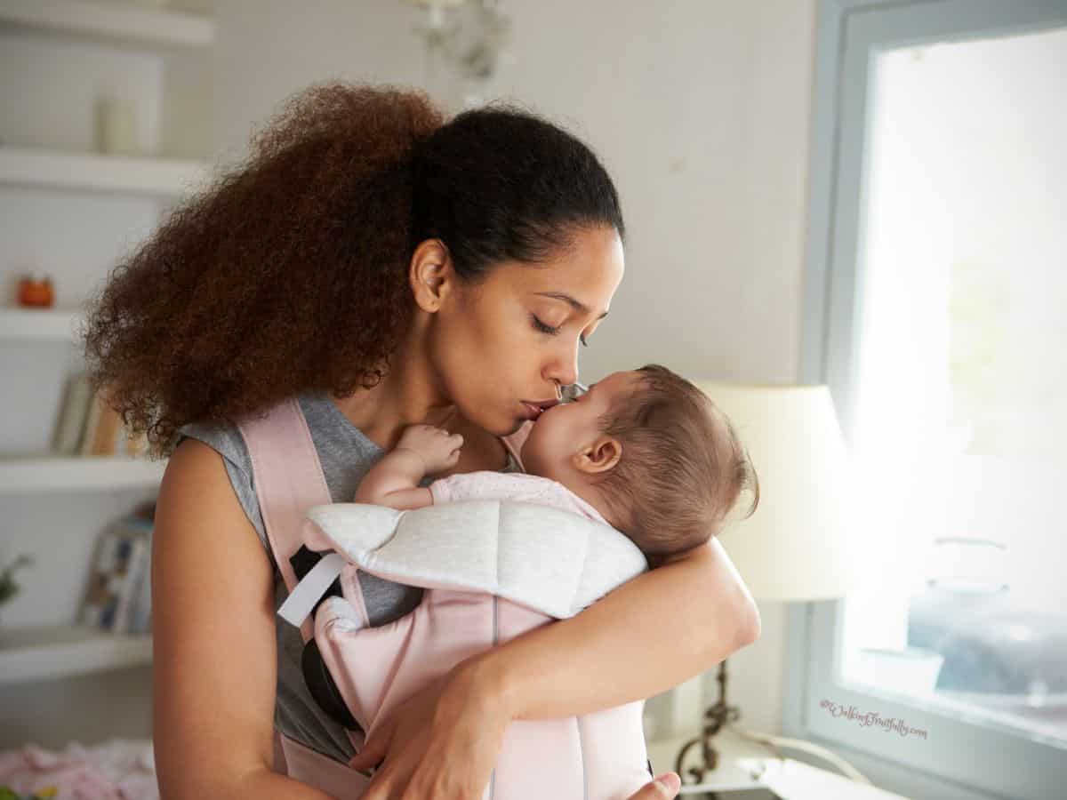 Mom holding little one, kissing nose