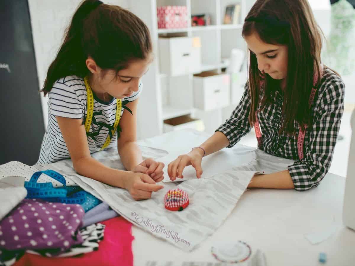 Two girls working together in sewing class with pins